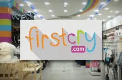 FirstCry.com logo displayed in a brightly lit retail store.